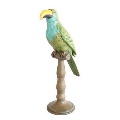 TOUCAN ON STAND GREEN & TURQUOISE 42X16CM "Add a touch of tropical charm to your home with our TOUCAN ON STAND in vivid green and turquoise. Crafted from durable materials, this 42x16cm figurine will brighten up any space. Perfect as a unique and stylish decor piece or as a gift for animal lovers."  Delivery fee 5 to 7 working days