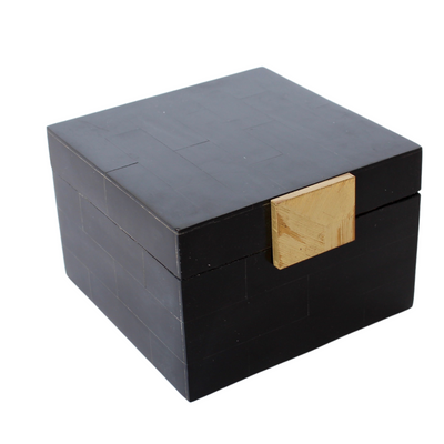 SQUARE BLACK BONE & GOLD BOX 11X15.5X15CM Expertly crafted from sleek black bone and accented with delicate gold embellishments, this stylish box brings a touch of sophistication to any space. Measuring 11x15.5x15cm, it is the perfect size for storing small trinkets or jewelry. Elevate your organization game while adding a touch of luxury to your home decor.     Delivery 5 to 7 working days