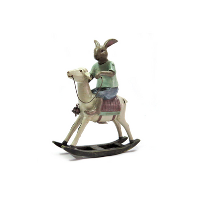 Expertly crafted and painted by hand, the Banbury Rabbit stands at 15.5cm in length, 6cm in width, and 20.5cm in height. With intricate details and a charming expression, this enchanting rabbit perches atop a rocking sheep. Sturdily built, it is both a work of art and a playful addition to any space.UNIQUE INTERIORS.