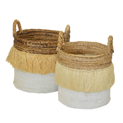 This set of two round baskets with grass tassels at the top is a beautiful addition to any home decor. The baskets are made from natural materials and come in a natural/white color combination. The set includes one large basket and one medium basket. Unique Interiors