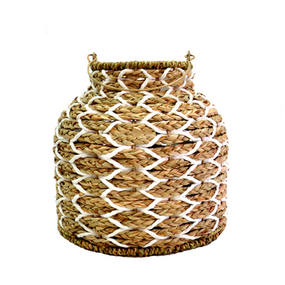 The Sunset Strip Lantern is expertly crafted with handwoven natural material rope, encircling a sturdy metal frame. The soft white accents in the weaving add a touch of elegance to this highly desirable lantern, measuring 14.5cm in top diameter and 26cm in both height and base. With a circumference of 82cm, it includes a metal frame and a glass insert (10cm x 10cm) inside-unique interiors