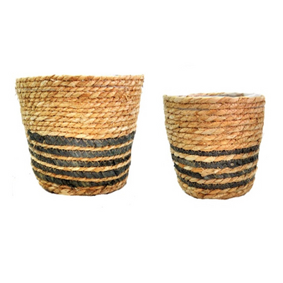 These Catalan Baskets S/2 are hand-woven with natural materials and lined with plastic for durability. The thin black stripes add an attractive touch, making these baskets not only useful, but also aesthetically pleasing. The set includes two sizes: 22cm top diameter x 18cm height for the larger basket and 17.5 cm top diameter x 15cm height for the smaller basket. Perfect for all your planter needs-unique interiors